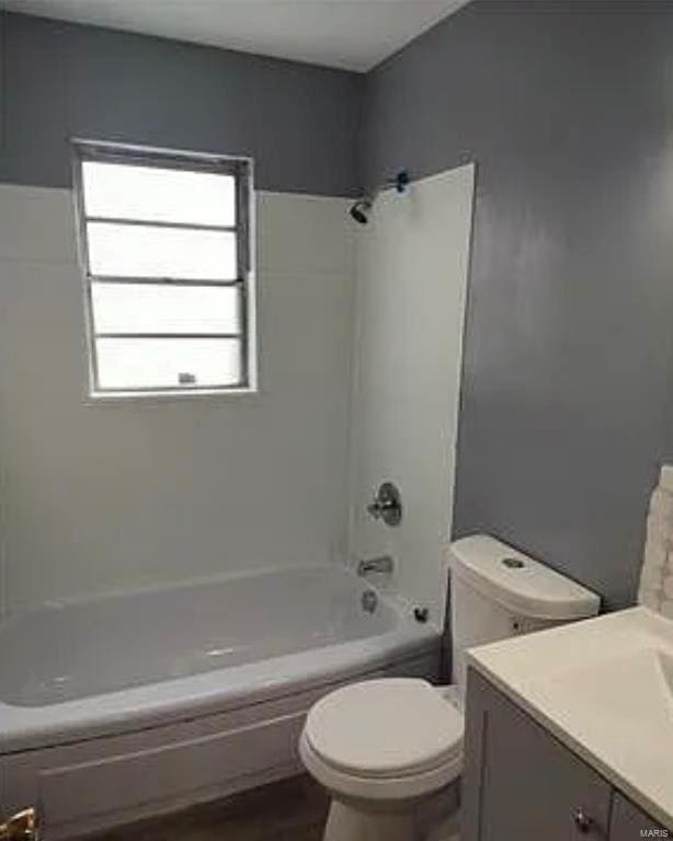 bathroom with shower / washtub combination, toilet, and vanity