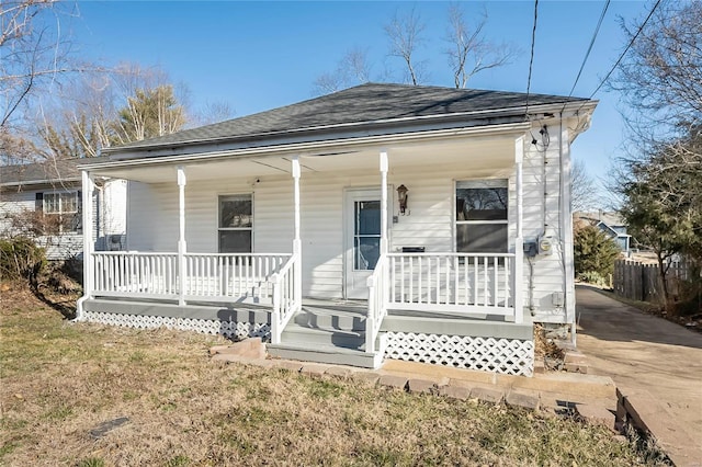 back of house with a porch and fence