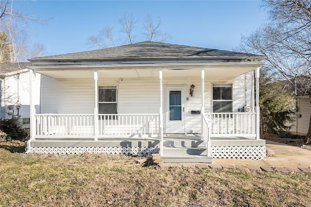 bungalow with a porch and a shingled roof