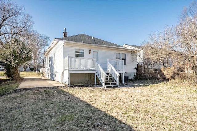 rear view of property with stairway and a chimney