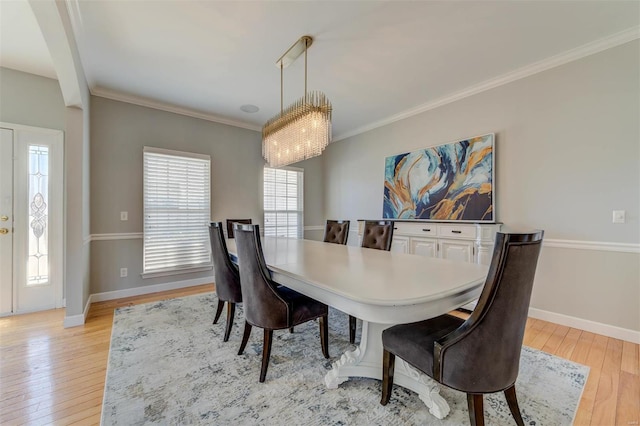 dining room featuring light wood finished floors, crown molding, and a wealth of natural light