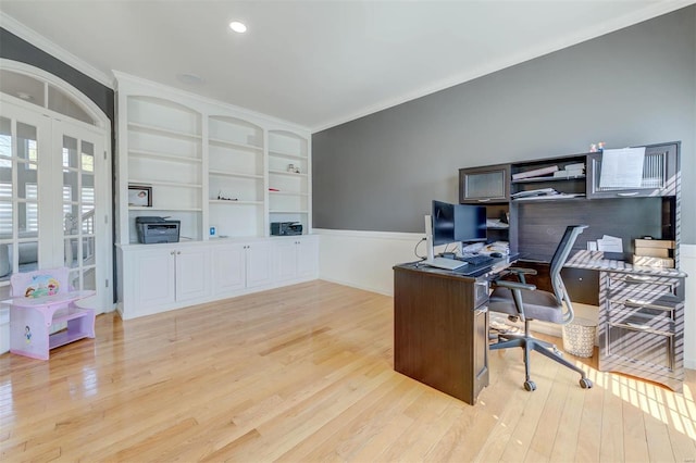 office with light wood-style flooring, built in shelves, and ornamental molding