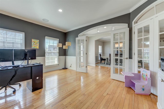 office with a wainscoted wall, arched walkways, hardwood / wood-style flooring, french doors, and crown molding