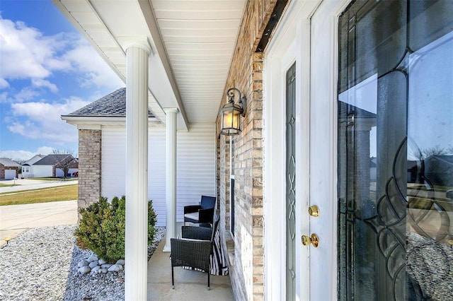 doorway to property with covered porch and roof with shingles