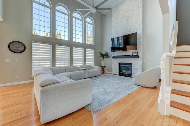 living area featuring hardwood / wood-style floors, stairway, a fireplace, and baseboards