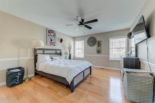 bedroom featuring a ceiling fan, baseboards, and light wood-type flooring