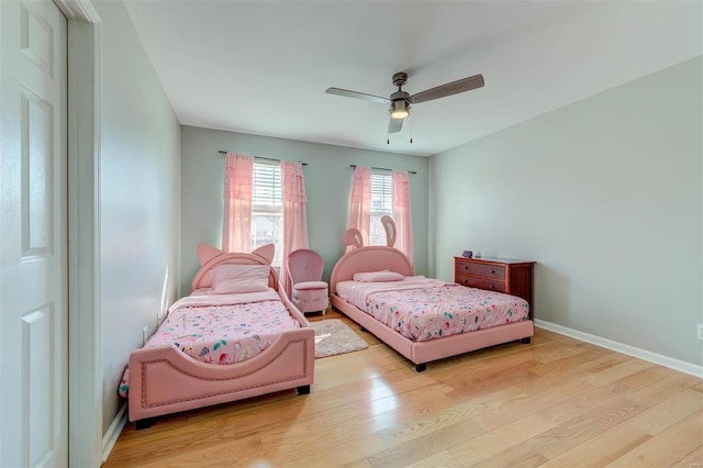 bedroom featuring ceiling fan, baseboards, and wood finished floors