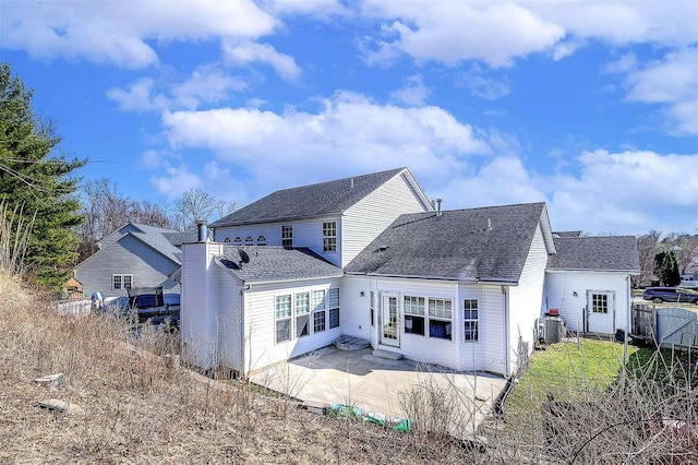 rear view of house featuring roof with shingles, a patio, and fence