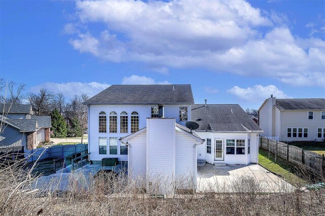 back of property with a patio area, a shingled roof, and a fenced backyard