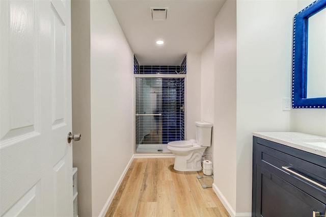 bathroom with vanity, wood finished floors, visible vents, a shower stall, and toilet