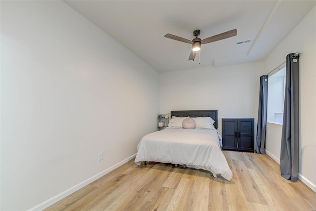 bedroom featuring ceiling fan, baseboards, visible vents, and light wood-type flooring