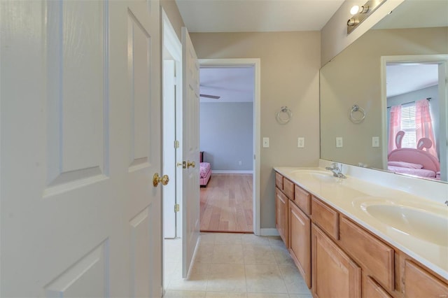 bathroom featuring double vanity, tile patterned floors, ensuite bathroom, and a sink