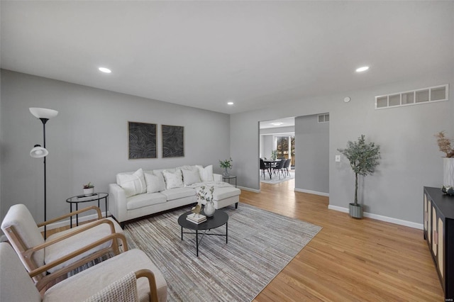 living room with baseboards, recessed lighting, visible vents, and light wood-type flooring