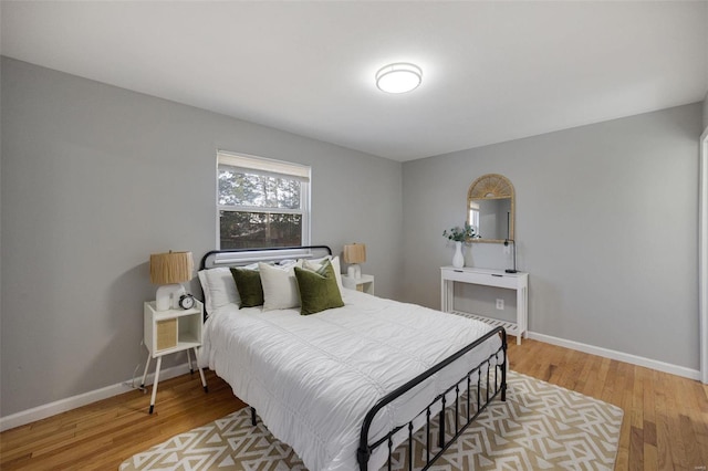 bedroom with baseboards and wood finished floors