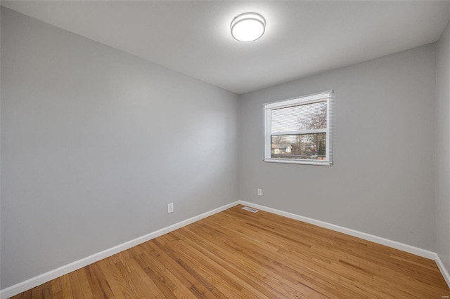 spare room with visible vents, baseboards, and light wood finished floors