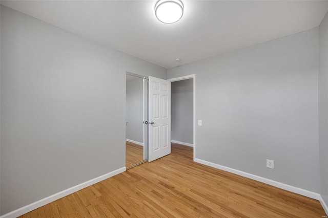 empty room with light wood finished floors and baseboards