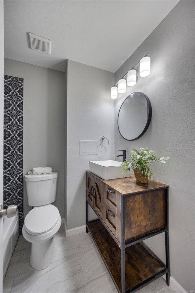 bathroom featuring vanity, toilet, baseboards, and visible vents