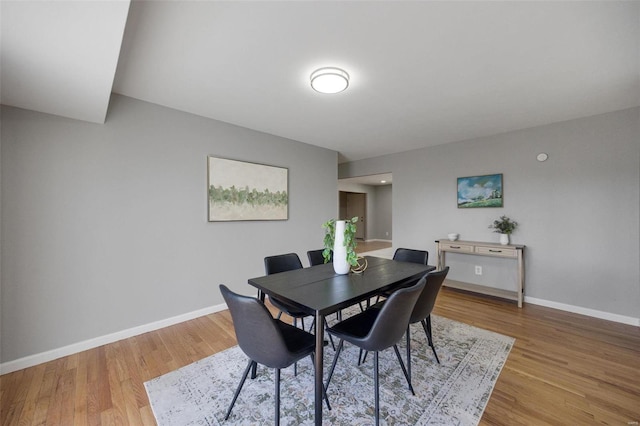 dining room with light wood-style flooring and baseboards