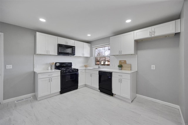 kitchen featuring visible vents, black appliances, white cabinets, light countertops, and baseboards