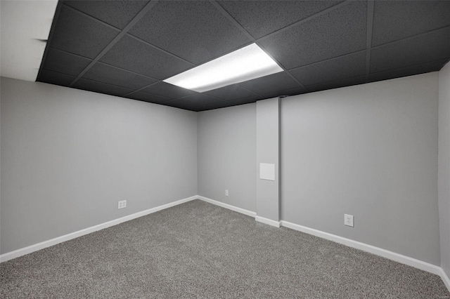 empty room featuring carpet, baseboards, and a paneled ceiling