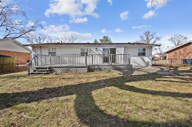 back of house featuring a wooden deck, a lawn, and fence