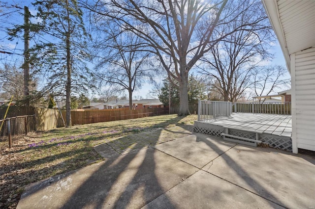 view of yard with a patio area, a wooden deck, and a fenced backyard