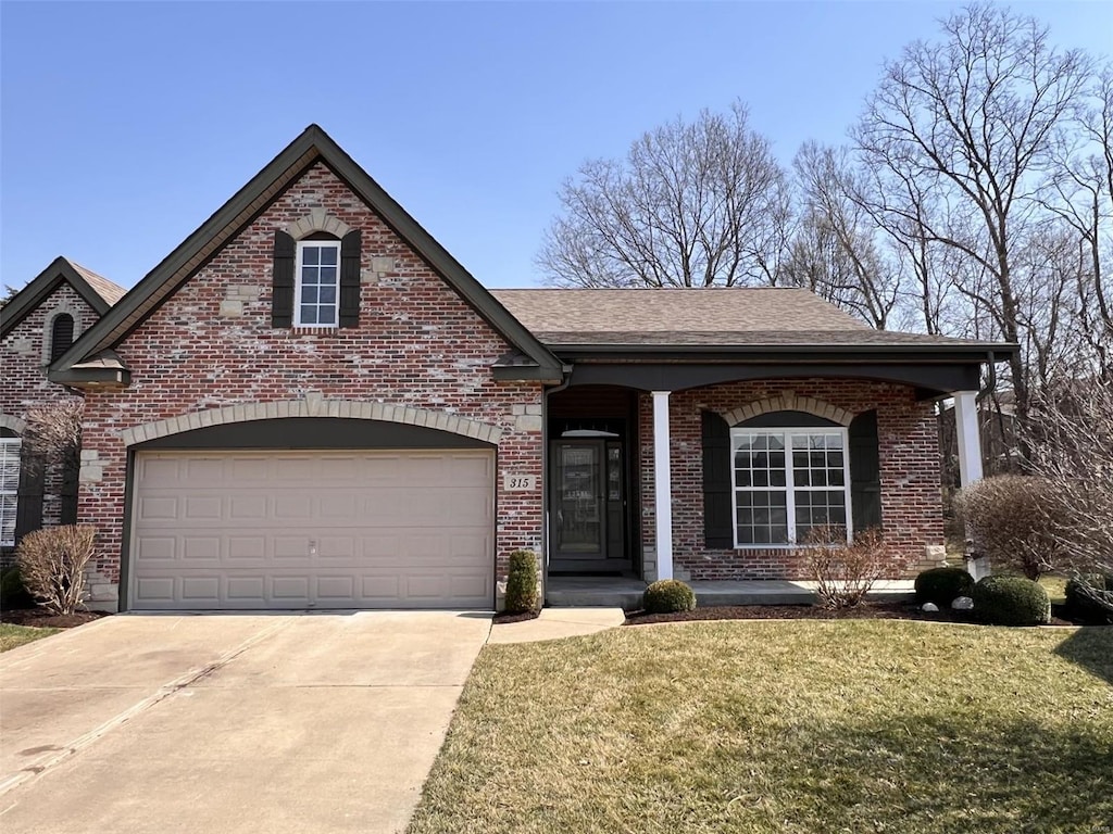 view of front of home featuring roof with shingles, a porch, a front lawn, concrete driveway, and brick siding