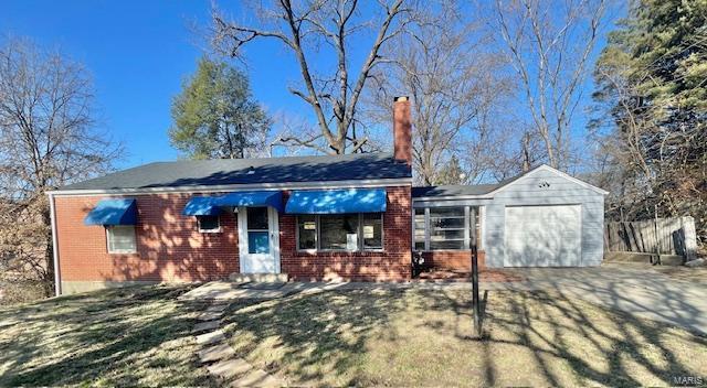 single story home with driveway, brick siding, and an attached garage