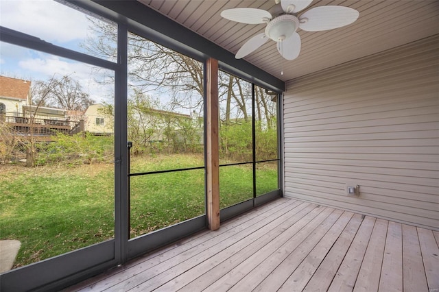 unfurnished sunroom with ceiling fan