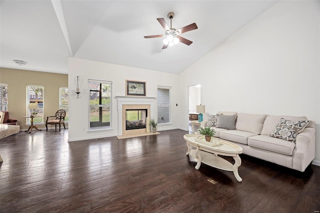living room featuring high vaulted ceiling, hardwood / wood-style flooring, baseboards, a fireplace, and a ceiling fan