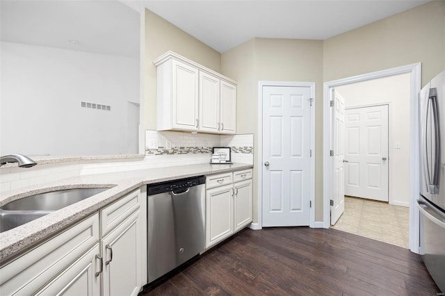 kitchen with a sink, white cabinets, visible vents, and stainless steel appliances