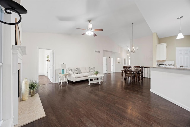 living room with ceiling fan with notable chandelier, high vaulted ceiling, dark wood-style floors, and visible vents