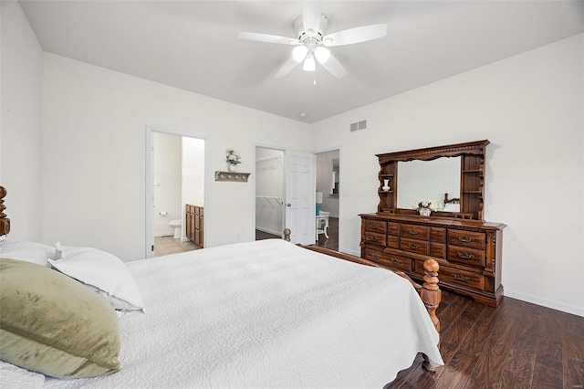 bedroom featuring connected bathroom, wood finished floors, baseboards, visible vents, and ceiling fan