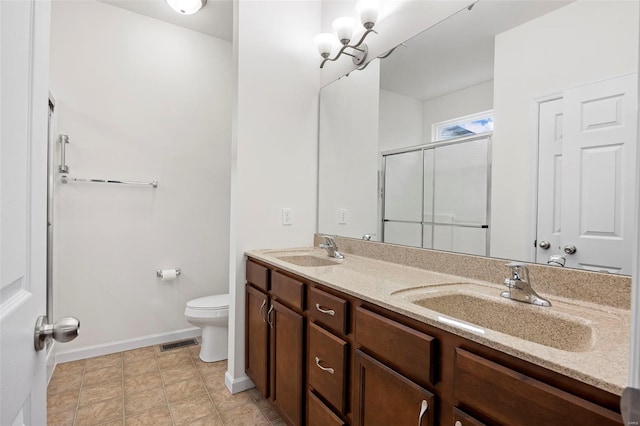 bathroom featuring toilet, a sink, a shower stall, and visible vents