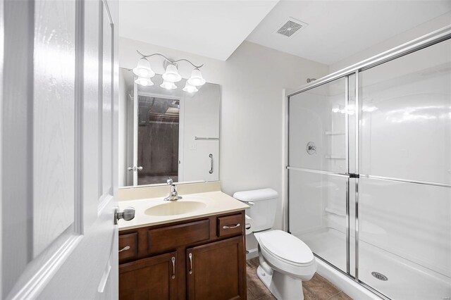 full bathroom featuring a stall shower, visible vents, toilet, and vanity