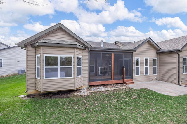 back of house featuring a patio area, central air condition unit, a shingled roof, a sunroom, and a yard