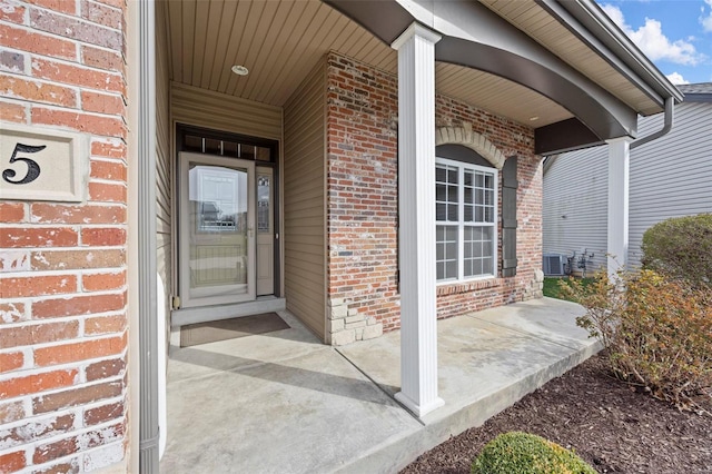 entrance to property with brick siding and a porch