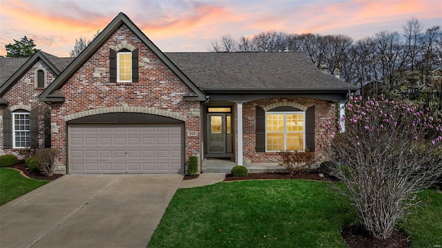 view of front facade with a garage, concrete driveway, brick siding, roof with shingles, and a yard