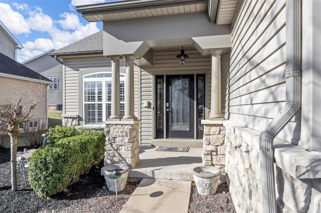 property entrance with a porch and stone siding