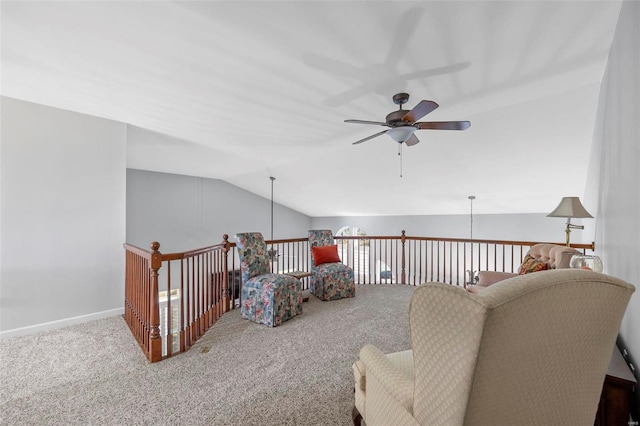 interior space with lofted ceiling, carpet flooring, a ceiling fan, and baseboards