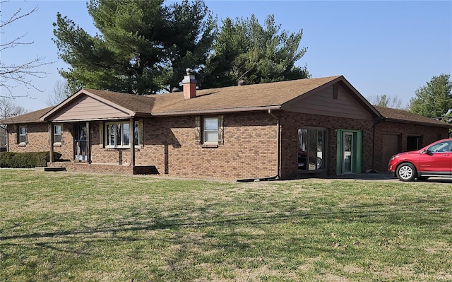 view of front of property featuring brick siding, a front lawn, a chimney, and an attached garage