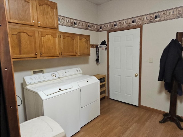 laundry area featuring cabinet space, light wood-type flooring, independent washer and dryer, and baseboards