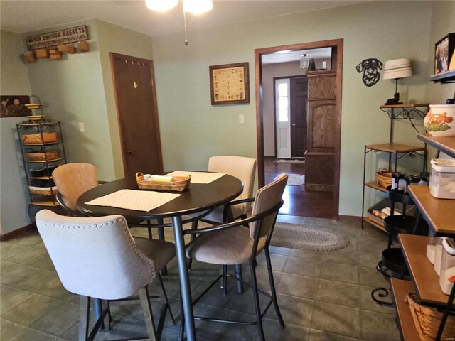 dining area with dark tile patterned flooring and baseboards