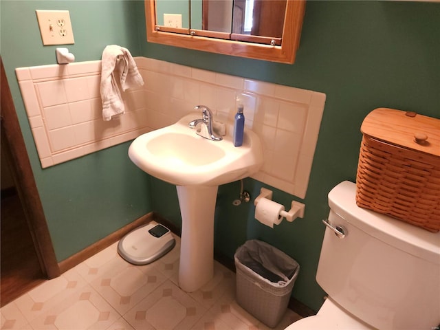 half bath with tasteful backsplash, toilet, and baseboards