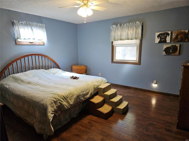 bedroom featuring ceiling fan, a textured ceiling, baseboards, and wood finished floors