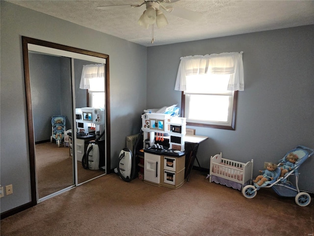 carpeted bedroom featuring a ceiling fan, a closet, and a textured ceiling