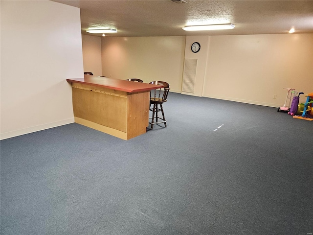 bar with dark colored carpet, baseboards, a textured ceiling, and a dry bar