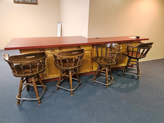 dining space with a dry bar and dark carpet