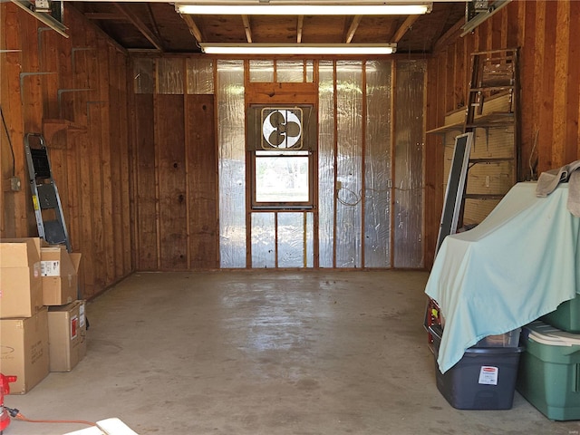 interior space with wood walls and concrete flooring