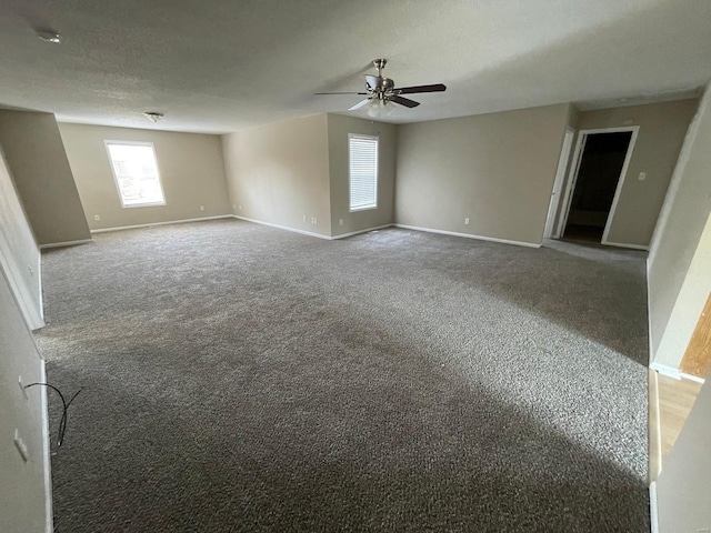 unfurnished room featuring a textured ceiling, baseboards, and carpet floors